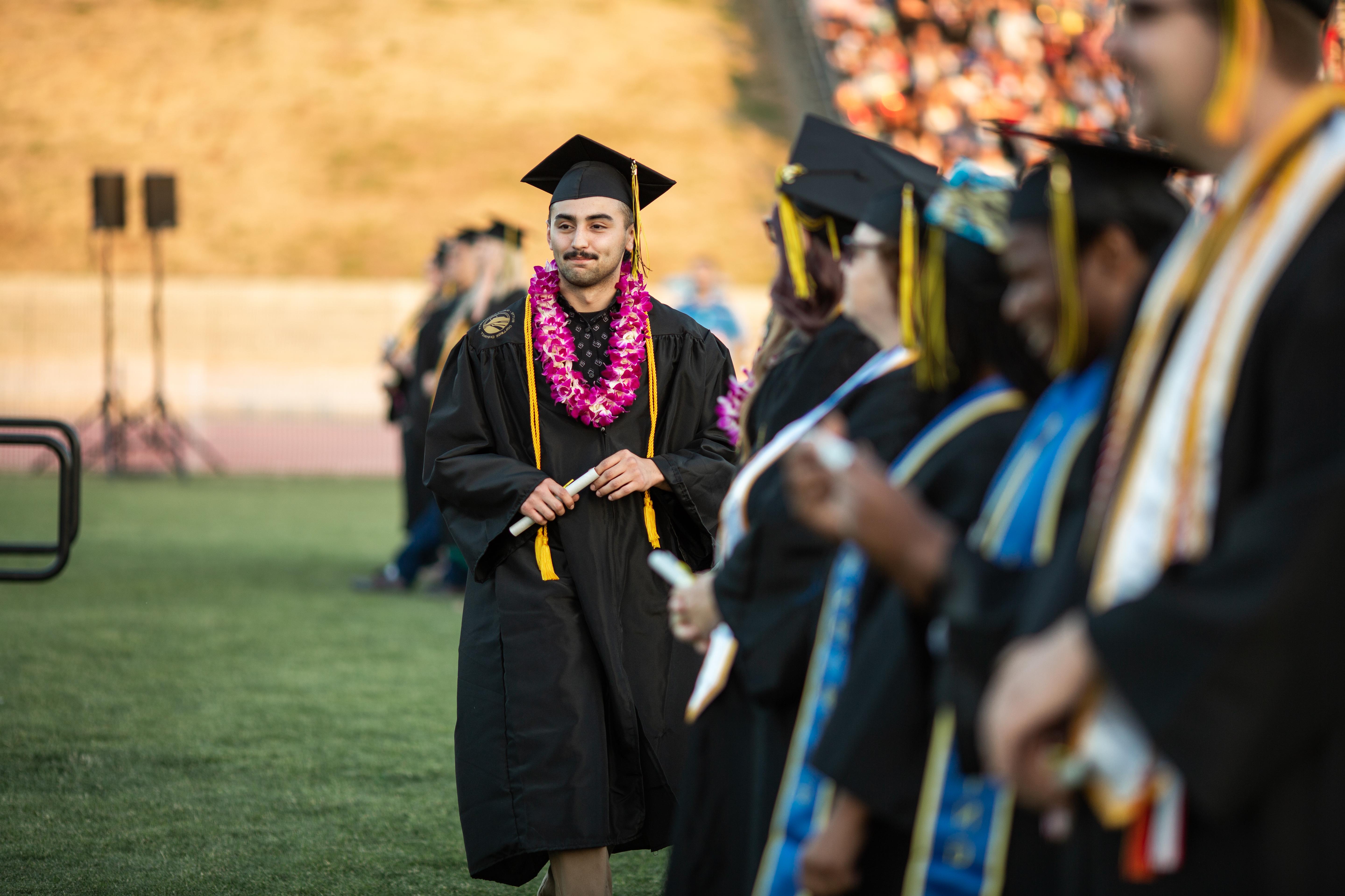 A group of graduates are shown participating in commencement.